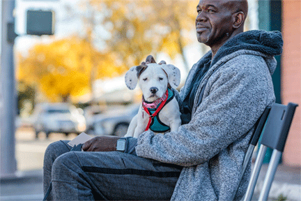 A good dog owner waits to get his puppy vaccinated and neutered at an owner support event in Oakland CA sponsored by BADRAP